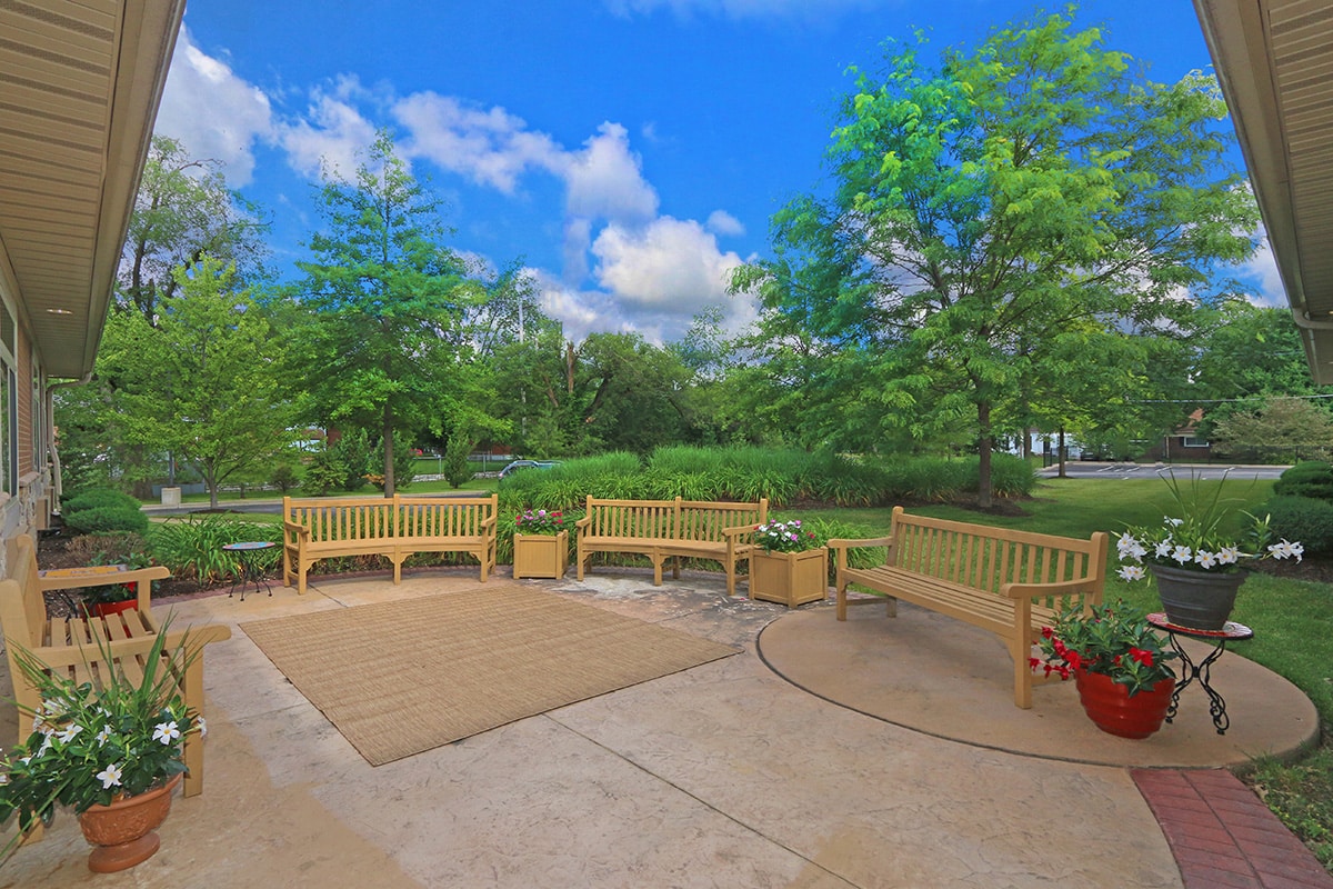 Outside patio with beautiful benches and green trees